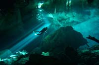 Diver in the middle of the light show at the cenotes Taj Maha